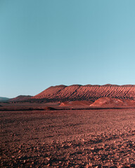 Red sand desert with blue sky at dawn, beautiful colors in the dunes and textured rippled cracked dirt