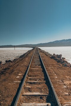  The railway of Tren a las Nubes going through snowy fields under blue sky in Salta, Argentina.Vertical shot