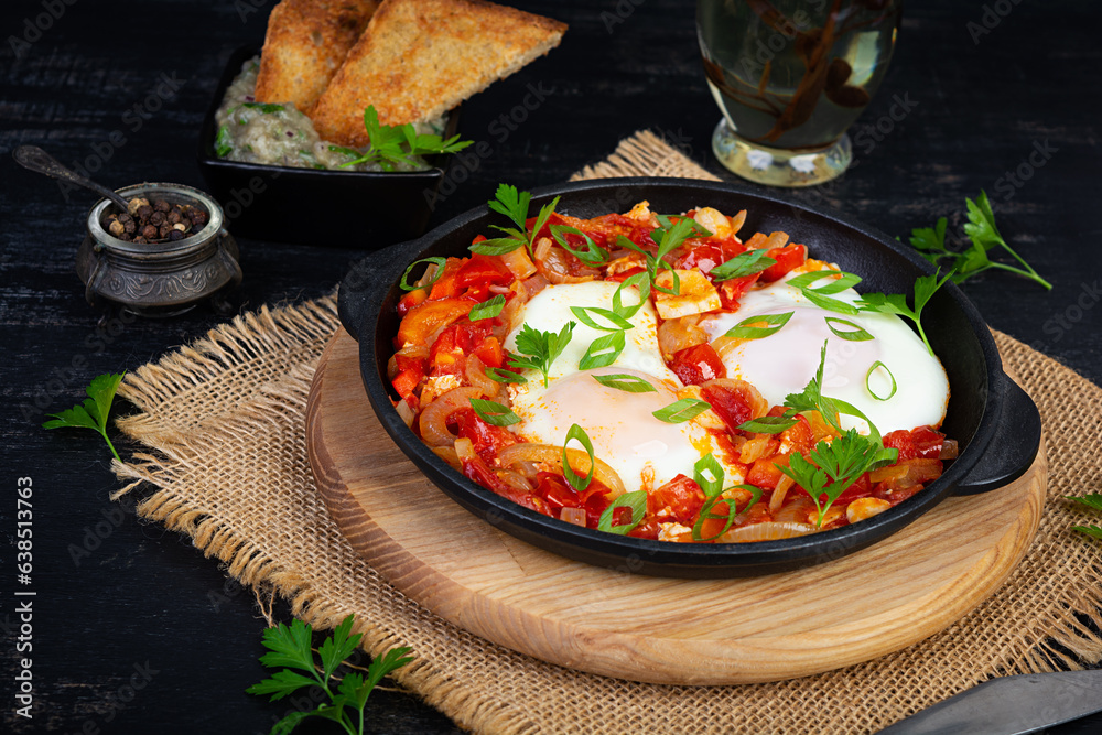 Wall mural Shakshuka with grilled bread. Fried eggs with tomato, pepper, garlic and herbs