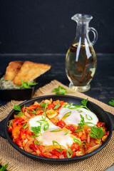 Shakshuka with grilled bread. Fried eggs with tomato, pepper, garlic and herbs