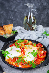 Shakshuka with grilled bread. Fried eggs with tomato, pepper, garlic and herbs
