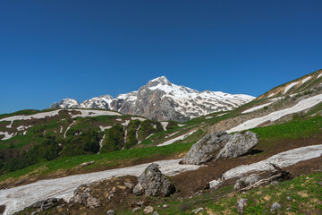 Glacier in the spring at the foot of the mountains. Vicinity of Mount Fisht in the Caucasus.