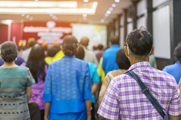 Fototapeta premium Back view of senior man wear face mask attending and listening to the annual meeting in the auditorium. Asian elderly active participants in conference room. Joyful listeners of business conference.