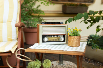 The FM channel is playing music, a stylish retro radio player stands on a wooden table. Close up...