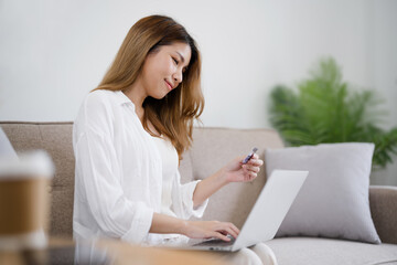 Happy asian woman using laptop and credit card for online payment, E-commerce