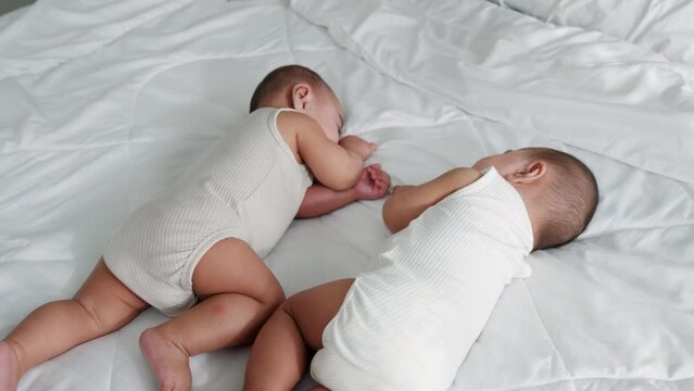 Happy childhood, Sleeping newborn identical boy twins on the bed on bedroom, Asian two adorable twin babies boy, family people infant