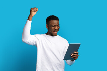 Excited young black man using digital pad and gesturing