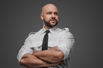 Robust bald man with beard in formal attire, confidently crossing arms, evoking themes of security,...