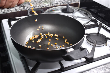 woman cooking popcorn at home to watch a movie