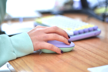 young woman using a lilac-colored mouse and keyboard
