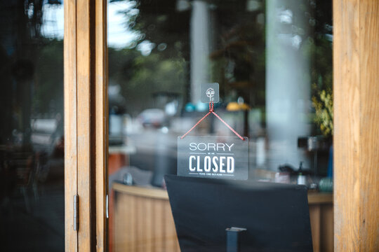 sorry we are closed sign hanging outside a restaurant, store, office or other