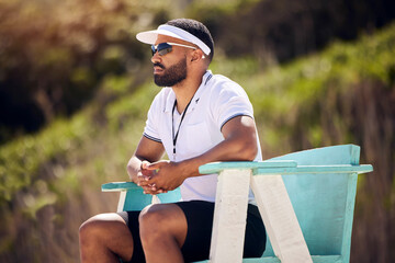 Summer, sports and a volleyball referee in a chair on the beach for authority, rules or regulations during a game. Health, professional or competition with a serious man refereeing a match in the day