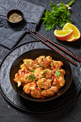crispy orange cauliflower florets in black bowl