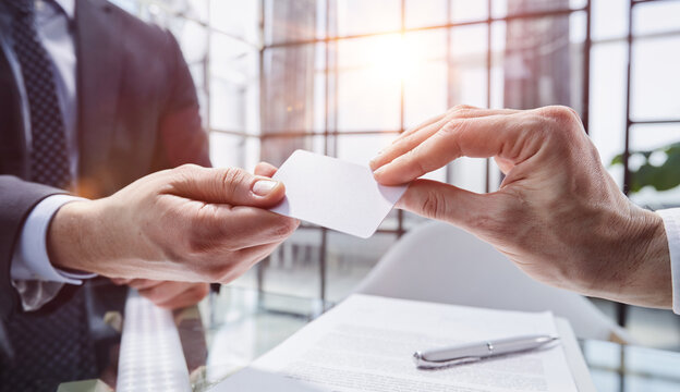 Business Manager Exchanging Business Card In Modern Office, Close-up