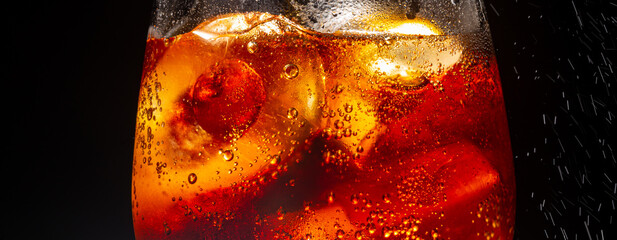 Cola glass with ice,Ice cubes in a glass of soda,Close-up iced cola isolated in the black background