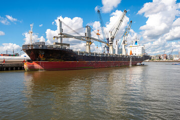 Cargo ship in the southwest port of Hamburg for loading and unloading at the quay. Fright transport and container shipment is a significant economic factor for the city of Hamburg 