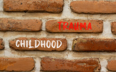 Childhood trauma symbol. Concept words Childhood trauma on beautiful brick wall. Beautiful red brown brick wall background. Business psychology childhood trauma concept. Copy space.