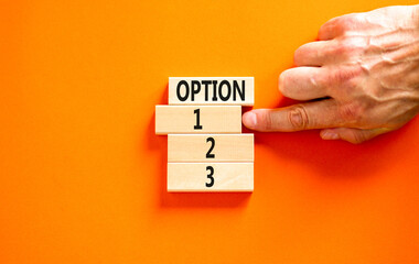 Time to option 1 symbol. Concept word Option 1 2 3 on wooden block. Businessman hand. Beautiful orange table orange background. Business planning and time to option 1 concept. Copy space.