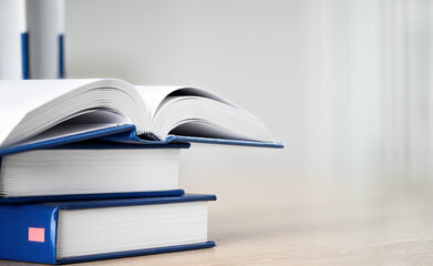 Stack of books with open book on table with copy space. Books background for business and education design, back to school concept.