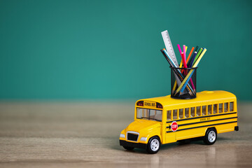 Toy school bus, back to school concept. Creative composition of yellow school bus carrying variety...