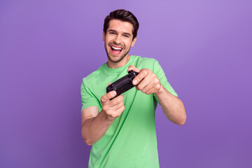 Photo of cheerful pleasant man with stubble dressed green t-shirt hold joystick play excited game...