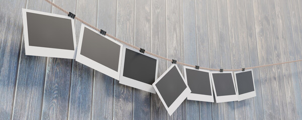 Photo frames hang on a rope secured with stationery clothespins. Empty photo frames 16x9 on a wooden background for your design. 3D visualization