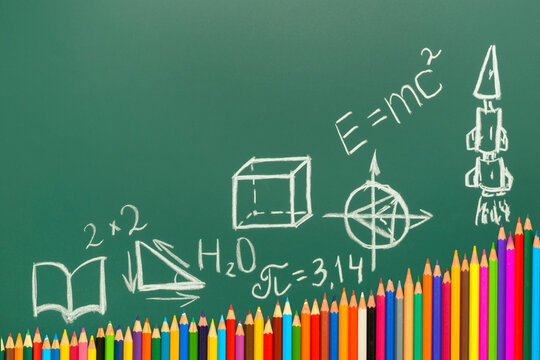 multicolored pencils on green chalkboard background, copy space, back to school concept and growth to knowledge, formulas, numbers, drawings, geometric shapes - Powered by Adobe