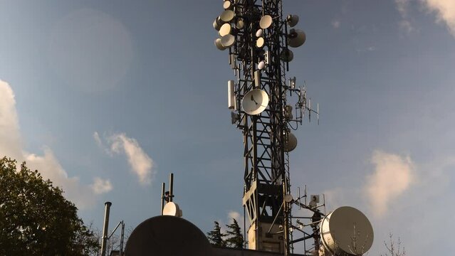 Time lapse of Telecommunication Antennas against blue sky with clouds, wireless transmission of mobile signal, broadcast of TV and radio.