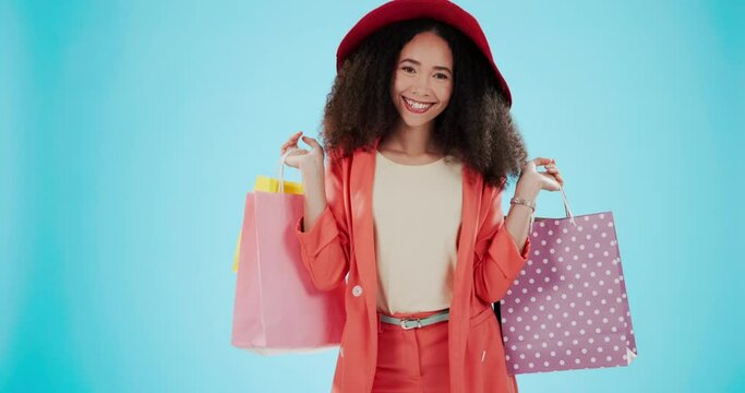 Fashion, shopping bag and spin with face of woman in studio for boutique, retail and excited. Product, choice and luxury with portrait of customer on blue background for promotion, gift and sales