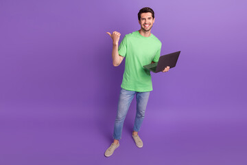 Full length photo of businessman workaholic while vacation job directing finger empty space hold netbook isolated on violet background
