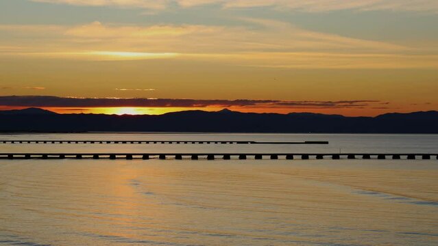 Time lapse of Sunrise from a beach over hills and sea - Grado Italy