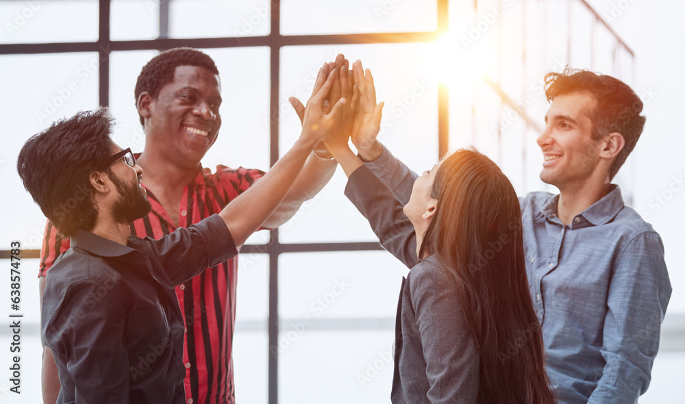 Wall mural Teamwork - business people with joint hands in the office