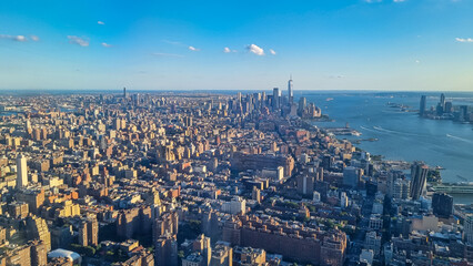 Fototapeta premium Captivating aerial view of New York City skyline over the Hudson River during the dusk seen from The Edge. Few white clouds above the city. Endless rows of tall buildings. Bustling and lively city
