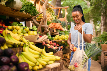 Female Customer At Market Stall Choosing Fresh Fruit And Vegetables