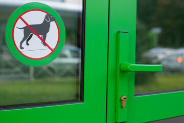 Sticker on the glass at the entrance to the building with a crossed-out dog. Sign prohibiting entry...