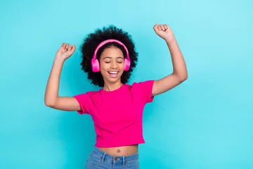 Foto auf Acrylglas Tanzschule Photo of funny funky carefree girl with afro chevelure wear pink t-shirt dancing in headphones hands up isolated on blue color background