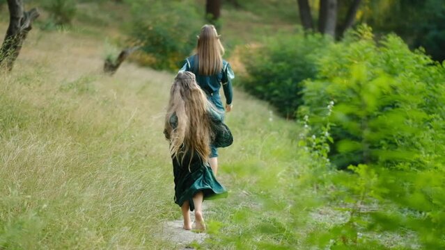 Beautiful elf girls are walking in a green dress in the forest.