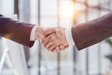 Building a strong business network. two businessmen shaking hands in a modern office.