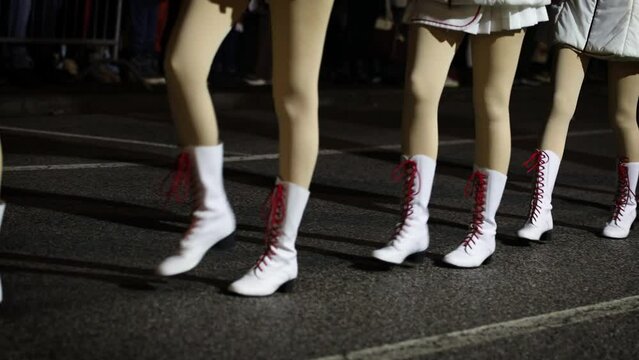Majorettes March in a Row on the street in the evening - Close up in the legs and Ground