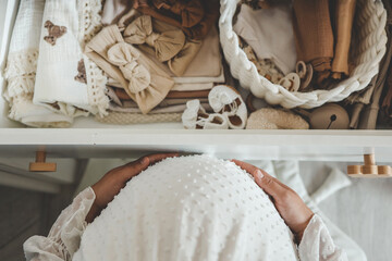 Pregnant woman is getting ready for the maternity hospital, packing baby stuff. pregnant woman preparing and planning baby clothes