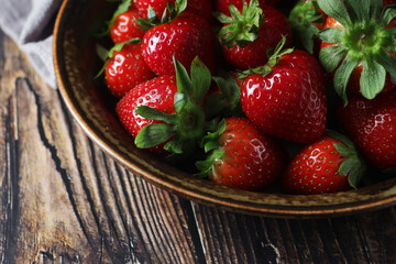 A bowl with ripe bright strawberry in rustic style