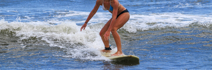 Fototapeta premium Teenage girl in a bikini surfing