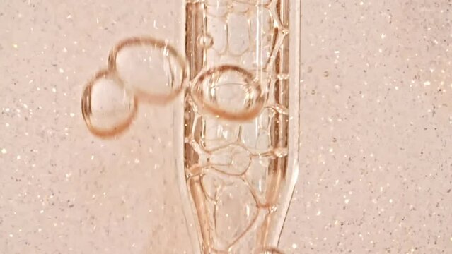 Transparent Cosmetic Gel Fluid With Molecule Bubbles and Oil Flowing in Glass Tube with Clear Liquid on White Background. Macro shot. Production Close-up. Slow Motion. High quality FullHD footage