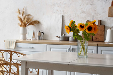 Vase with sunflowers on dining table in modern kitchen