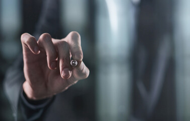 Left hand writing with marker on transparent board on black background