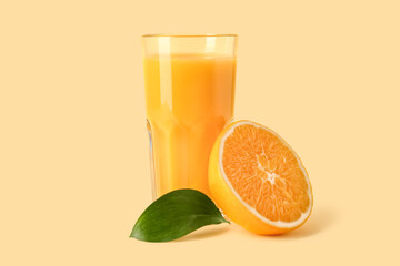 Glass of fresh orange juice on yellow background