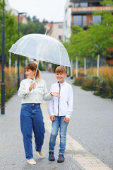 A mother and son holding umbrella and playing outdoors 