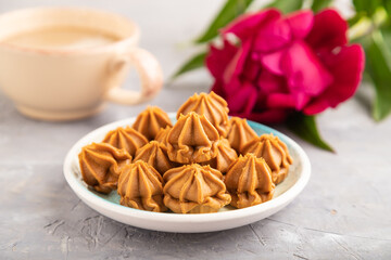 Homemade soft caramel fudge candies on gray concrete, side view, selective focus
