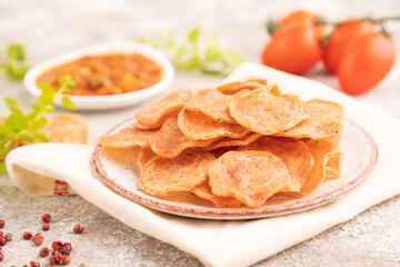 Slices of dehydrated salted meat chips on gray concrete, side view, selective focus