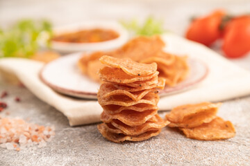 Slices of dehydrated salted meat chips on gray concrete, side view, selective focus